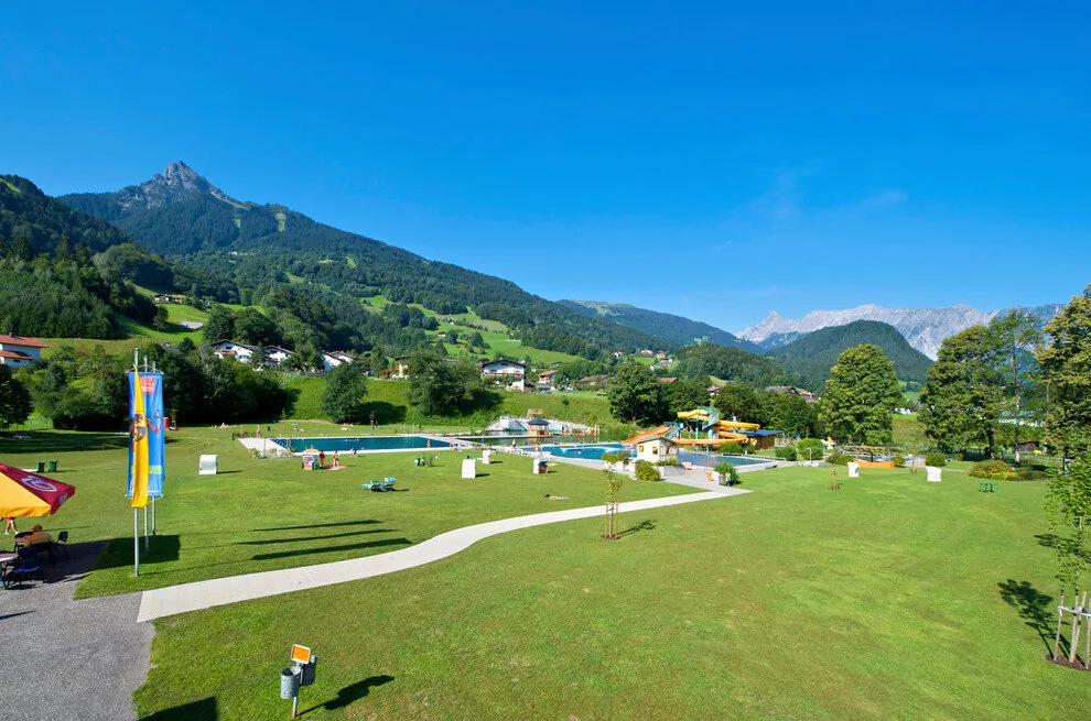 Het Alpenbad Montafon in Tschagguns met zwembaden, ligweide en bergen op de achtergrond
