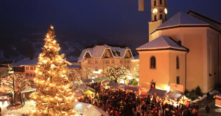 Verlichte kerstboom en kerkplein van Schruns tijdens de Silbriga Sonntig Markt